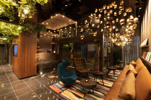 a lobby with a couch and chairs and a chandelier at The Cloud One New York-Downtown, by the Motel One Group in New York