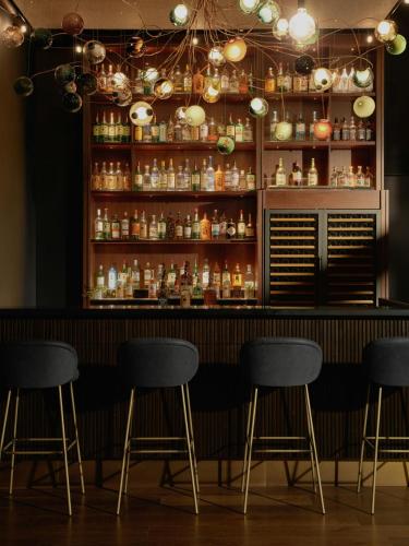 a bar with four stools in a room at The Cloud One New York-Downtown, by the Motel One Group in New York