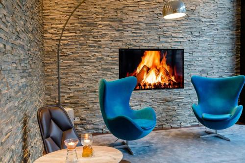 two blue chairs sitting in front of a fireplace at Motel One München-Sendlinger Tor in Munich