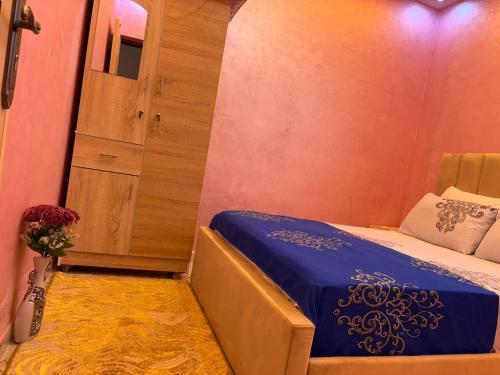 a small bedroom with a bed and a cabinet at Small beautiful villa in Al Massira Airport