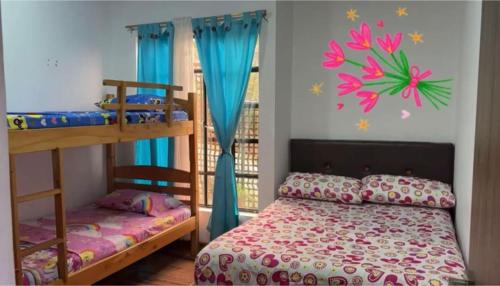 a bedroom with two bunk beds and blue curtains at Finca cuatro orquídeas in La Mesa