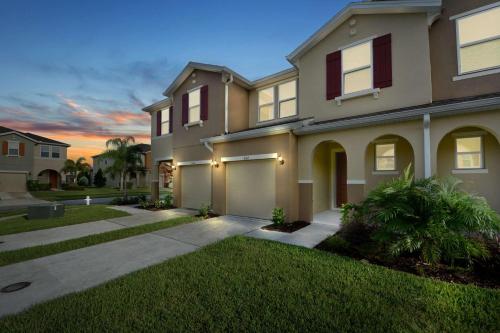 a large house with a garage in a yard at Four Bedrooms Townhouse 5102 in Kissimmee