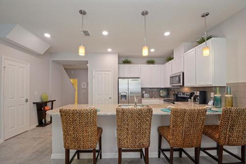 a kitchen with a large island with bar chairs at Four Bedrooms Townhouse 5102 in Kissimmee