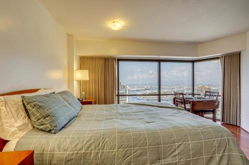 a bedroom with a bed and a view of a city at Free Parking Pool Harbor View Access Honolulu Gem! in Honolulu