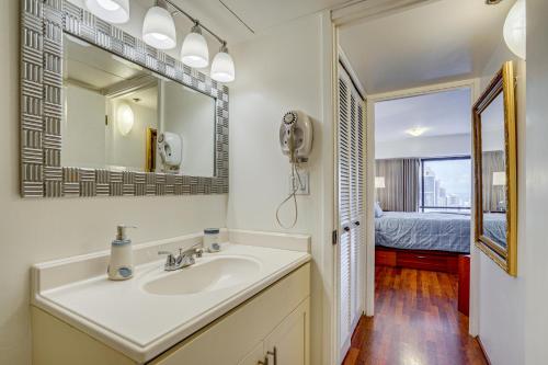 a bathroom with a sink and a mirror and a bed at Free Parking Pool Harbor View Access Honolulu Gem! in Honolulu