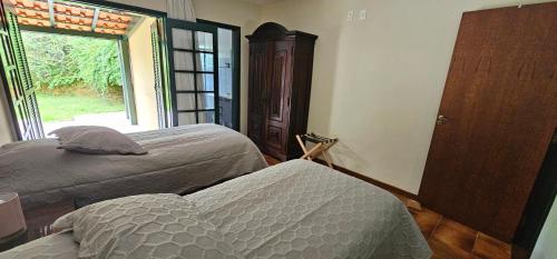 a bedroom with two beds and a window at Pousada dos Anjos in Cunha