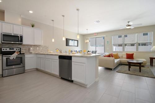a kitchen with white cabinets and a living room at Four Bedrooms TownHome 5130 in Kissimmee