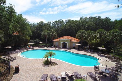 an overhead view of a swimming pool with chairs and trees at Four Bedrooms TownHome 5130 in Kissimmee