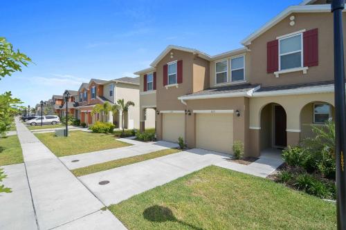 a house on a street with a driveway at Four Bedrooms TownHome 5130 in Kissimmee