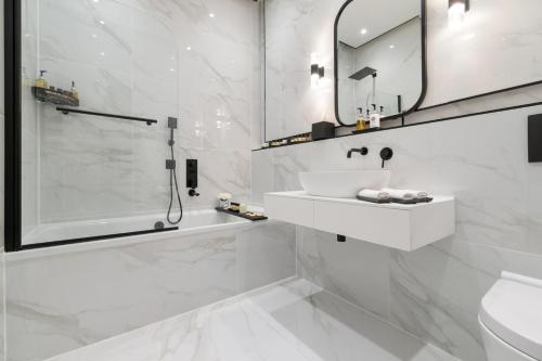 a white bathroom with a sink and a shower at Luxury Georgian City Retreat by Sovo Apartments in Edinburgh