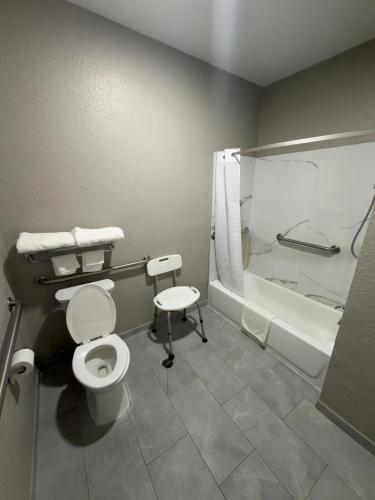 a bathroom with a toilet and a bath tub at Super 8 by Wyndham Houston/Brookhollow NW in Houston