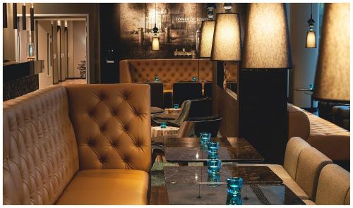 a restaurant with couches and a table and chairs at Motel One London-Tower Hill in London