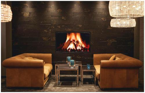 a living room with two chairs and a fireplace at Motel One London-Tower Hill in London
