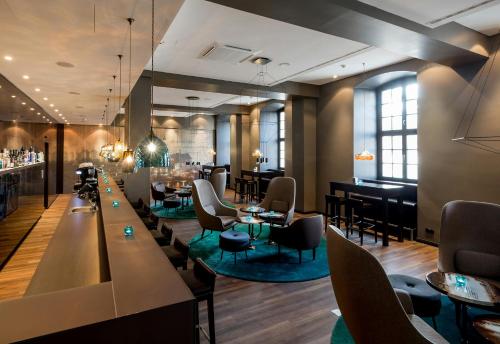 a restaurant with tables and chairs and a bar at Motel One Magdeburg in Magdeburg