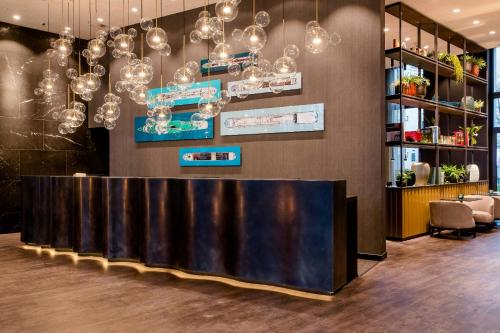 a bar in a room with chandeliers at Motel One Köln-Altstadt in Cologne