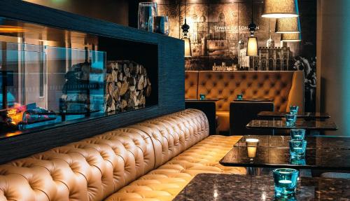 a brown leather bench in a restaurant with tables at Motel One London-Tower Hill in London