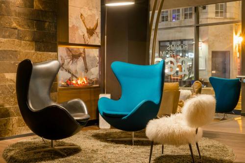 a lobby with three chairs and a fireplace at Motel One Manchester-Royal Exchange in Manchester
