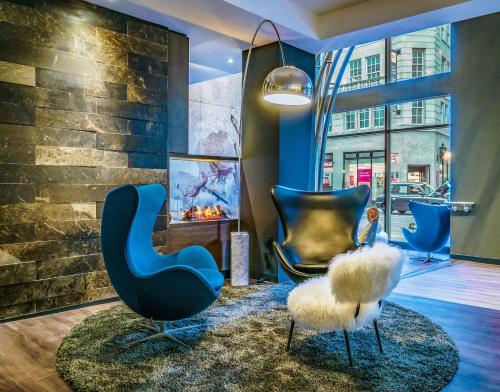a lobby with two blue chairs and a fireplace at Motel One Manchester-Royal Exchange in Manchester