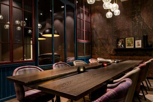 a dining room with a wooden table and chairs at Motel One Manchester-St. Peter's Square in Manchester