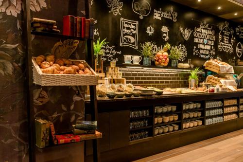 a bakery with bread and other food items on display at Motel One Manchester-St. Peter's Square in Manchester