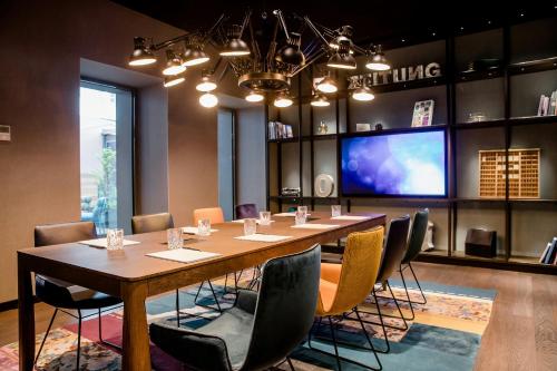a conference room with a long table and chairs at Motel One Hannover-Oper in Hannover