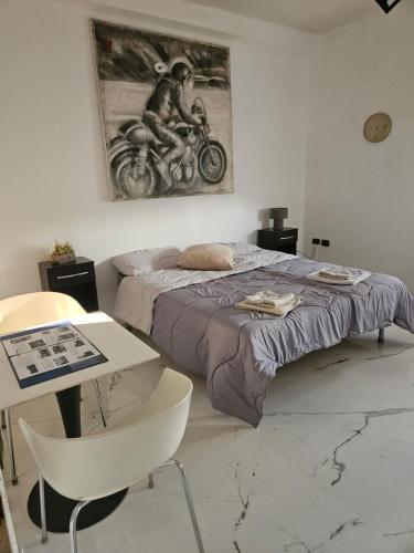 a bedroom with a bed and a table and a painting at VILLA GIOVANNA in Bergamo