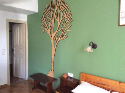a bedroom with a tree painted on the wall at Eleni Studios in Agios Nikolaos