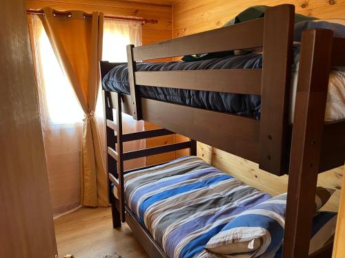 a couple of bunk beds in a room with a window at Cabañas Sra Mery in Quilimarí