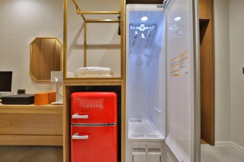 a red refrigerator in a room with a cabinet at 통영 하운드호텔 죽림점 in Naejuk-to