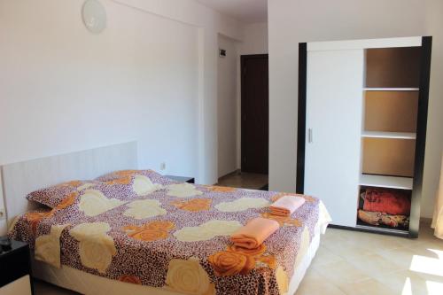 een slaapkamer met een bed in een kamer met een spiegel bij Tangra Guest House in Arapya