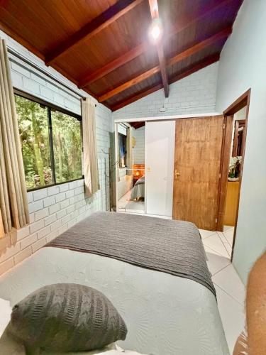 a bedroom with a large bed and a window at Sítio Harmonia! in Harmonia