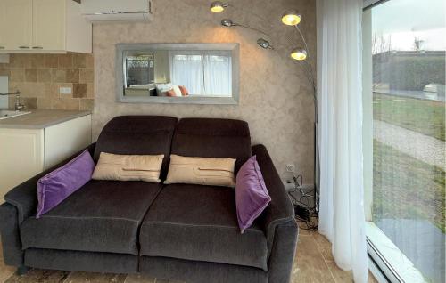 a living room with a brown couch with pillows at Studio Tout Confort in Fondettes