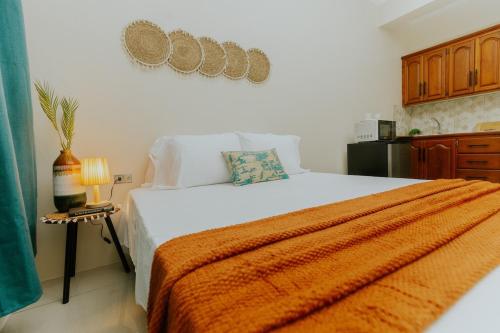 a bedroom with a large bed with an orange blanket at Bali-Inspired Studio Mins from Airport in Arima