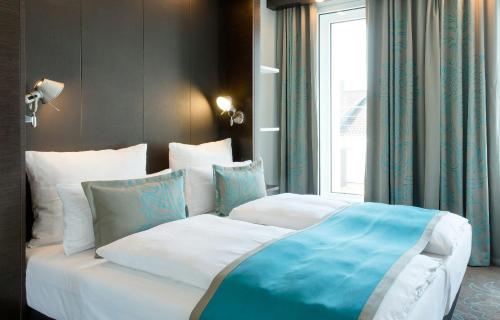 a bedroom with two beds and a window at Motel One Stuttgart-Bad Cannstatt in Stuttgart