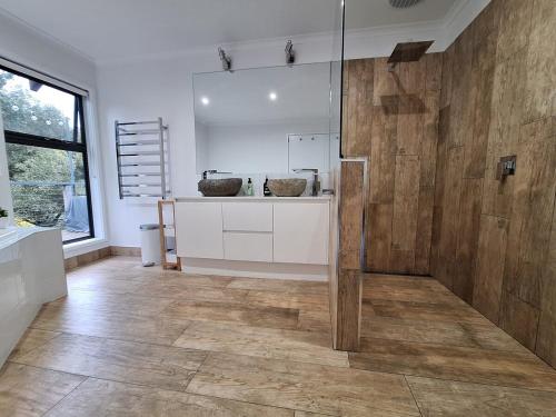 a bathroom with a shower with a wooden wall at Moonlight Ridge Chalet in Merrijig