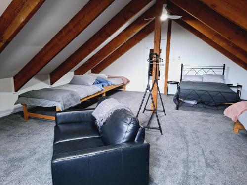 a living room with two beds and a leather couch at Moonlight Ridge Chalet in Merrijig