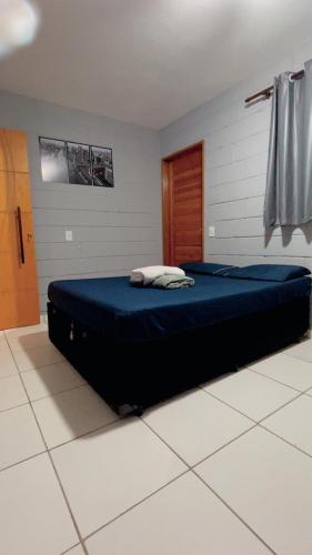 a bedroom with a large bed with blue sheets at Quarto Familiar Próximo ao Aeroporto de Guarulhos in Guarulhos