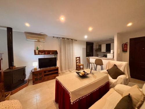 a living room with a couch and a table and a tv at Apartamento La alberca 1 in Aracena