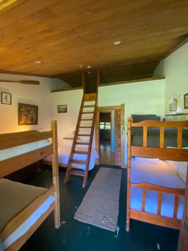 a room with three bunk beds and a ladder at The Farm in Whangaruru
