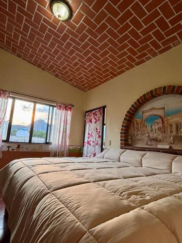 a large bed in a room with a brick ceiling at Hotel-Posada Kali Tlayacapan in Tlayacapan