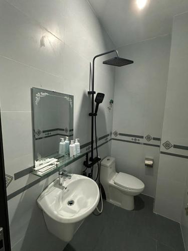a white bathroom with a sink and a toilet at Motel Mai Thu in Thăng Bình