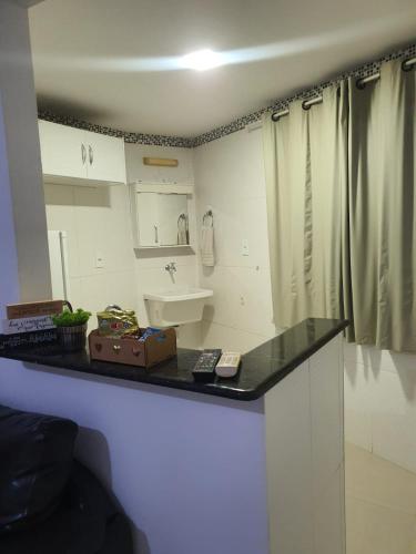 a bathroom with a sink and a counter top at Kitnet no Centro Garagem, ar e Wi-Fi in Itaperuna