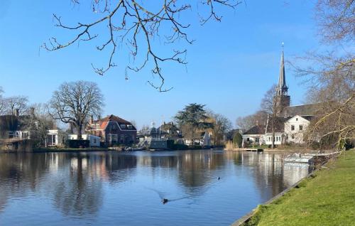 a view of a river with houses and a church at Awesome Apartment In Broek In Waterland With Wifi in Broek in Waterland