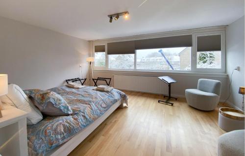 a bedroom with a bed and a chair and a window at Awesome Apartment In Broek In Waterland With Wifi in Broek in Waterland