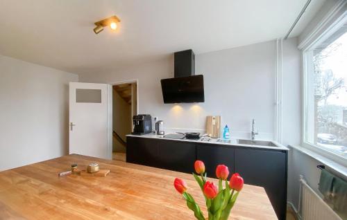 a kitchen with a table with red flowers on it at Awesome Apartment In Broek In Waterland With Wifi in Broek in Waterland