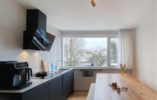 a kitchen with a table and a large window at Awesome Apartment In Broek In Waterland With Wifi in Broek in Waterland