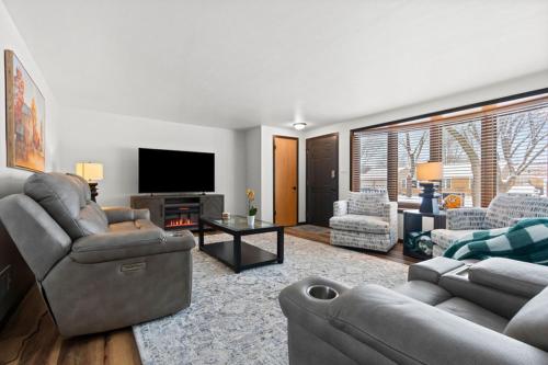 a living room with couches and a flat screen tv at Three Bedroom Ranch walking distance to Lambeau in Green Bay
