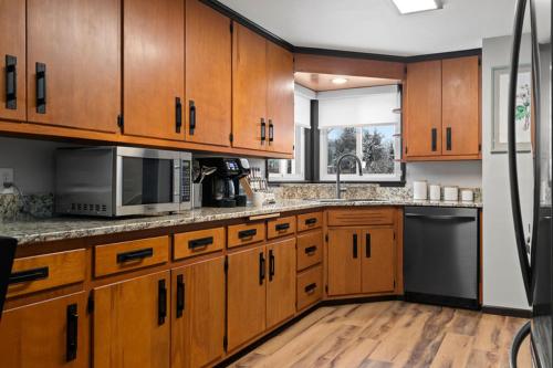 a large kitchen with wooden cabinets and a sink at Three Bedroom Ranch walking distance to Lambeau in Green Bay