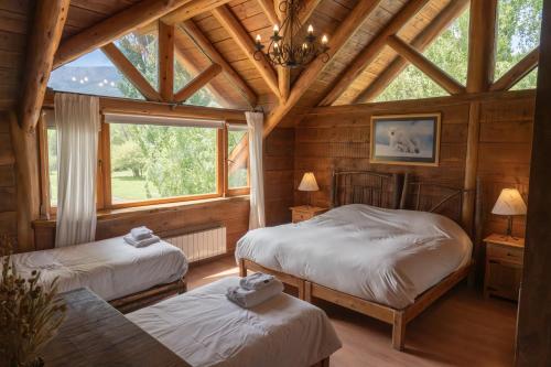 a bedroom with two beds and a large window at Estancia Peuma Hue in San Carlos de Bariloche