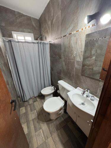 a bathroom with a white toilet and a sink at Casa de 2 dormitorios, zona parque in Necochea